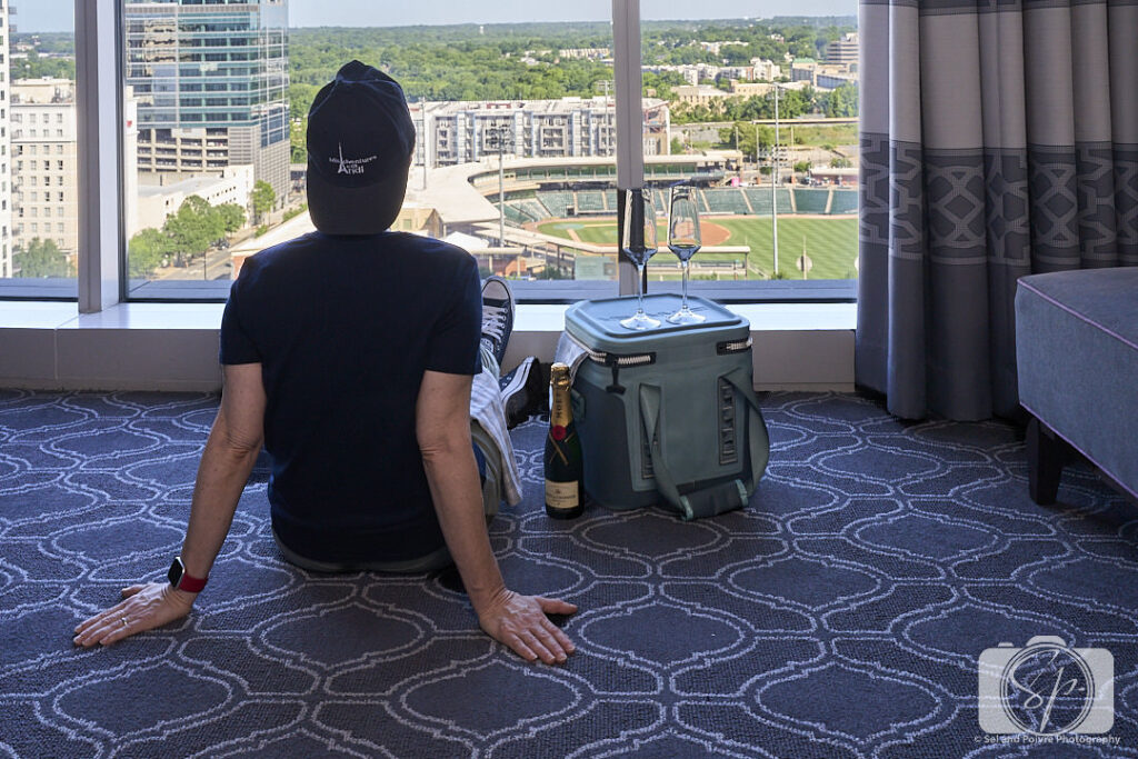 Andi watching the baseball game from her Kimpton Tryon Park Hotel room