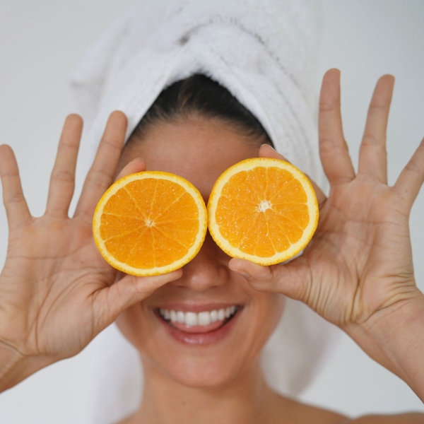 beauty in towel turban smiling with oranges