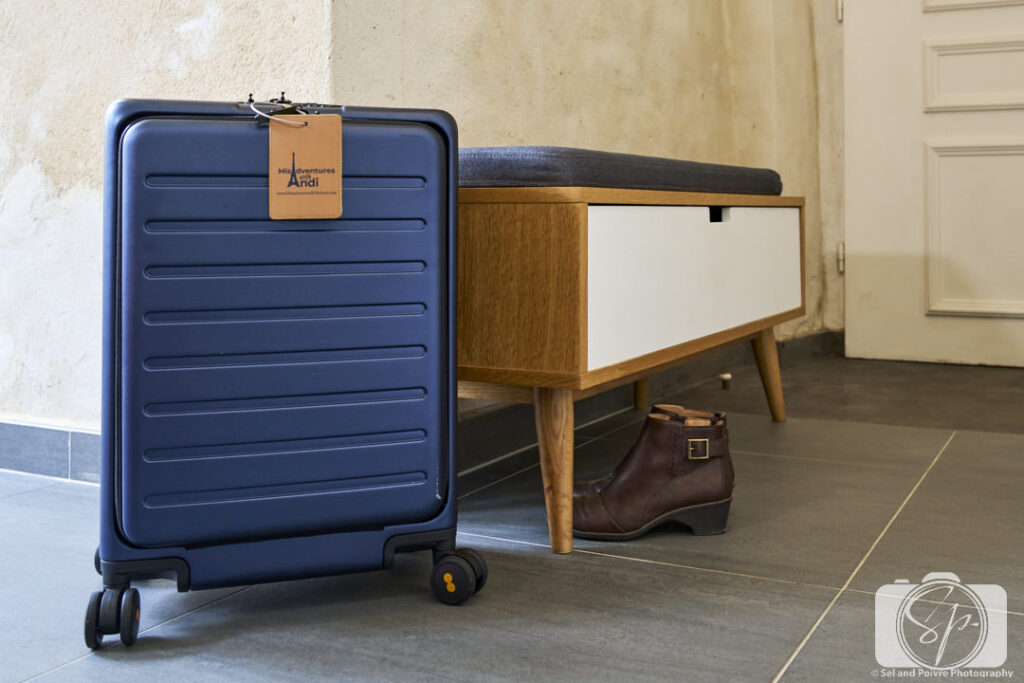 Level 8 Suitcase and Jambu Giselle Ankle Boots near a bench